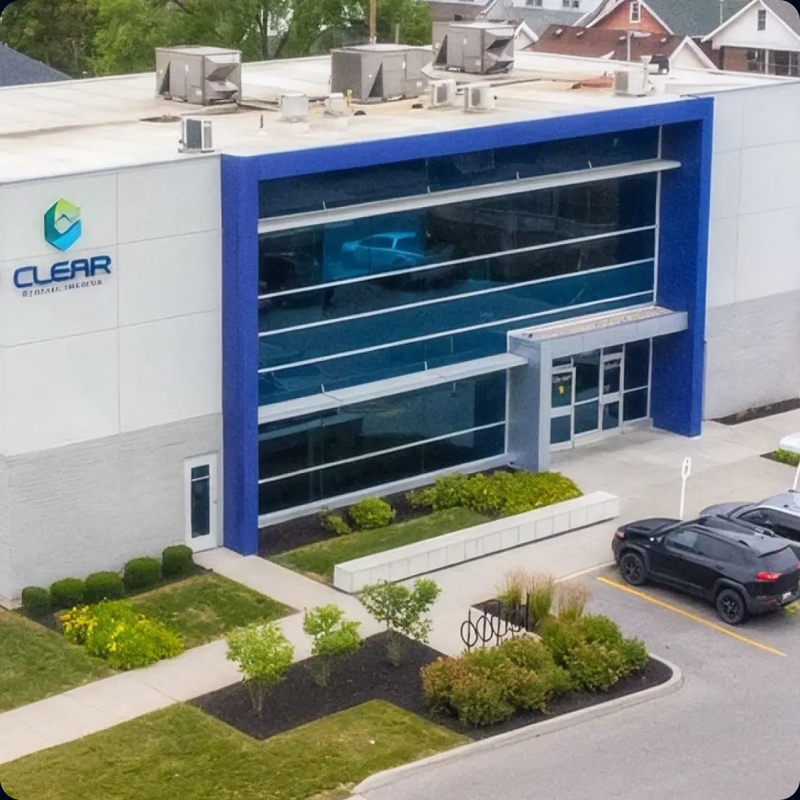 Aerial view of a Clear Medical Imaging centre, a modern building with a blue-framed glass facade.