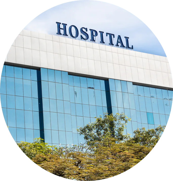 Glass-fronted hospital building with a rooftop hospital sign
