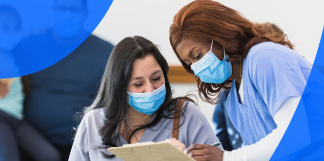 Healthcare professional showing female patient her chart in hospital waiting room wearing masks