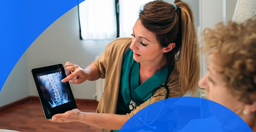 Healthcare professional showing X-ray of spine to woman