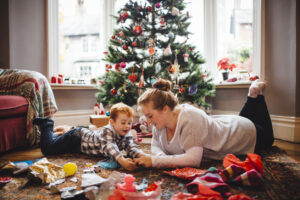 Mother and son playing with newly opened presents on Christmas morning