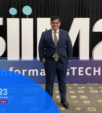 PocketHealth CEO Rishi Nayyar Standing in Front of 2023 SIIM Conference Sign